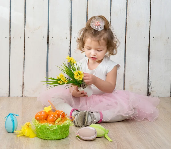 Nettes kleines Mädchen auf dem Boden sitzend mit Blumentopf in der Hand — Stockfoto