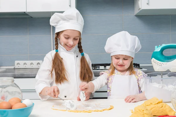 Chef malzemeler tablo ile Tekdüzen içinde iki küçük kız — Stok fotoğraf