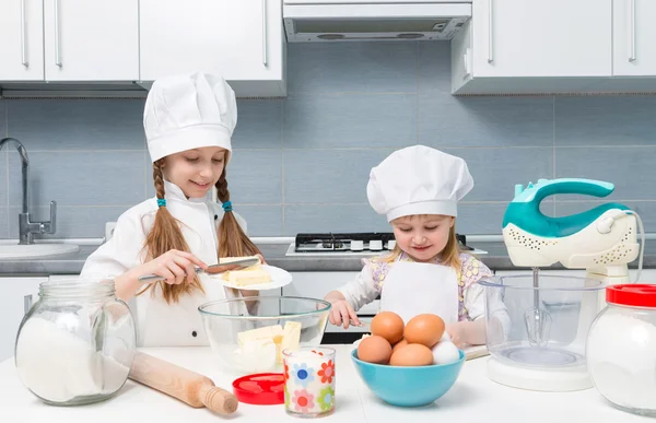 Due bambine cuoche che tagliano il burro per impasto — Foto Stock