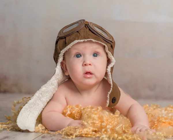 Precioso bebé en sombrero piloto en el suelo —  Fotos de Stock