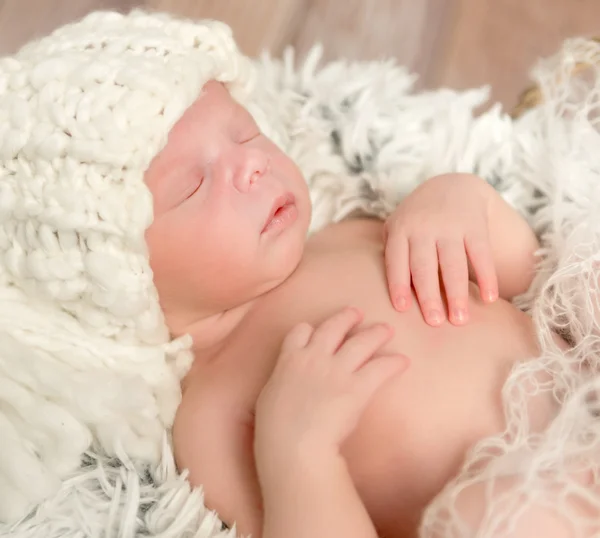 Lovely newborn baby in knitted white hat — Stock Photo, Image