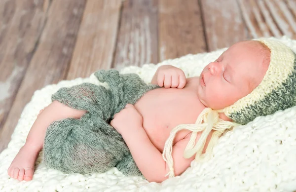 Sleepy swaddled newborn baby in knitted hat — Stock Photo, Image