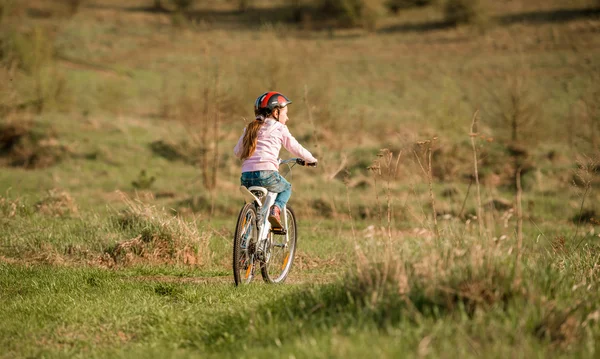 Sorrindo menina andando de bicicleta virou costas — Fotografia de Stock