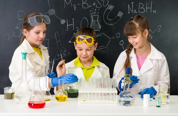 Three little students on chemistry lesson in lab Royalty Free Stock Photos