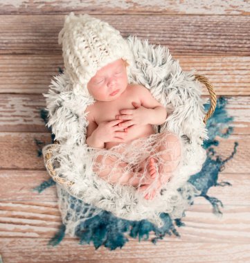 kürk üzerinde beyaz örgü şapkalı minik yeni doğan bebek