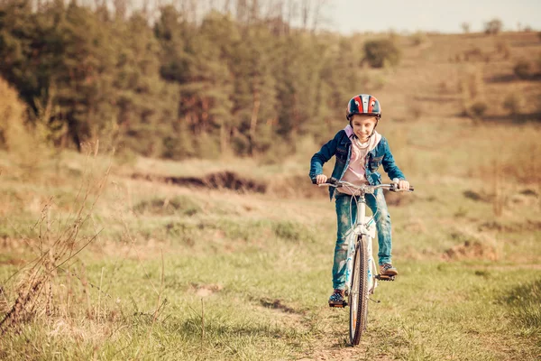 Niña sonriente montando una bicicleta — Foto de Stock