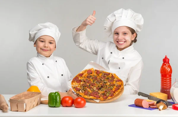 少年と白ピザ付きのテーブルで制服の少女 — ストック写真