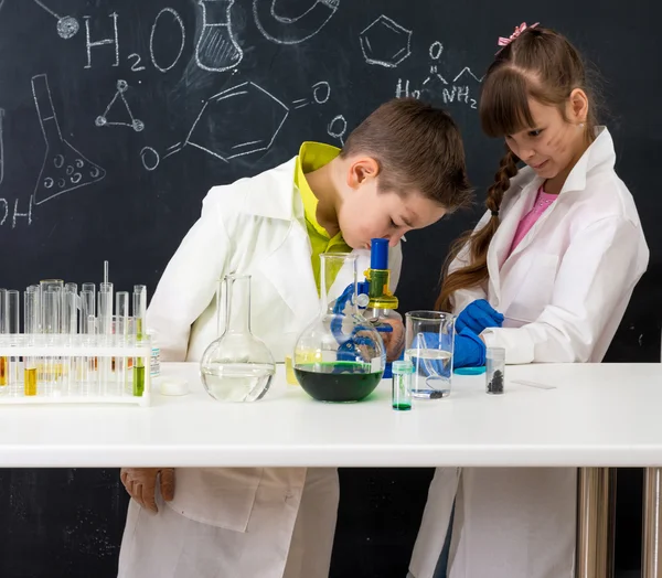Два школьника смотрят химический эксперимент — стоковое фото