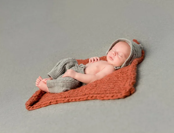 little newborn baby sleeping on knitted blanket