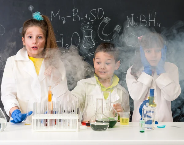 Drei aufgeregte lustige Kinder nach Chemie-Experiment im Labor — Stockbild Drei aufgeregte Kinder nach chemischem Experiment — Stockfoto