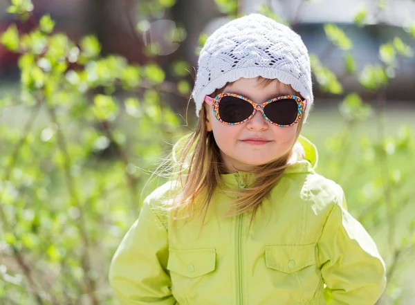 Pequena menina sorridente em óculos de sol — Fotografia de Stock
