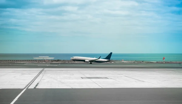 Letadlo v Lanzarote letiště utečence s mořem v pozadí — Stock fotografie