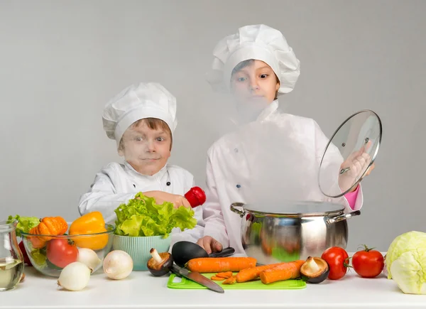 Little cooks by the kitchen table in steam — Φωτογραφία Αρχείου