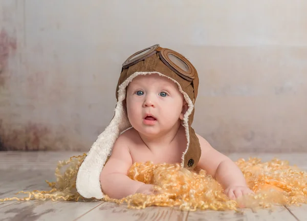 Bel bambino in cappello da pilota sul pavimento — Foto Stock