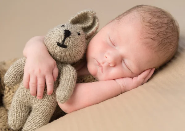Doce bebê recém-nascido abraçando brinquedo-lebre — Fotografia de Stock