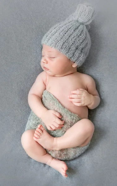 Nouveau-né en chapeau gris avec petite couverture — Photo
