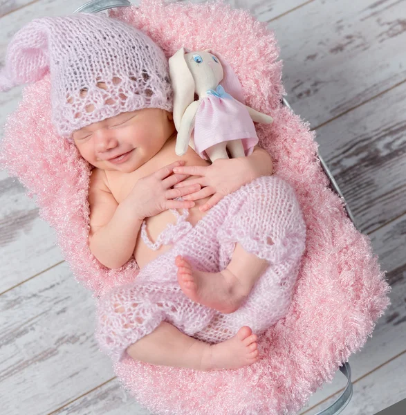 Sorrindo bebê recém-nascido menina com uma lebre de brinquedo — Fotografia de Stock