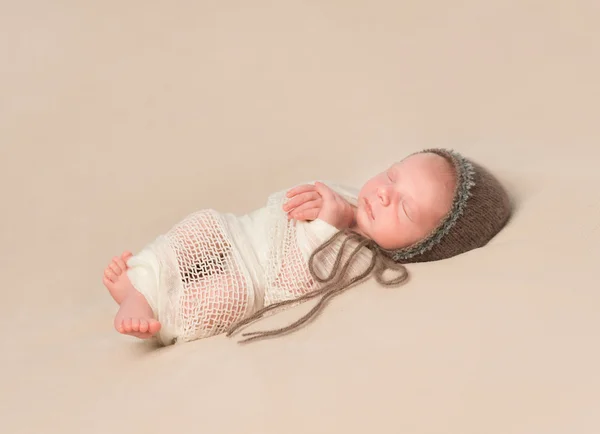 Sleepy swaddled newborn baby in knitted hat — Stock Photo, Image