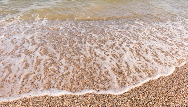 Ola suave espumosa en la orilla del mar — Foto de Stock