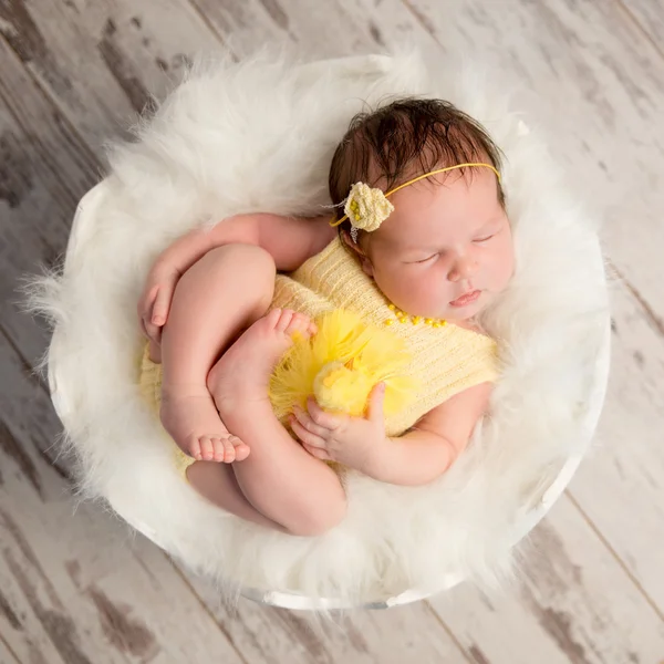 Lustiges schlafendes Baby im gelben Strampler auf rundem Kinderbett — Stockfoto