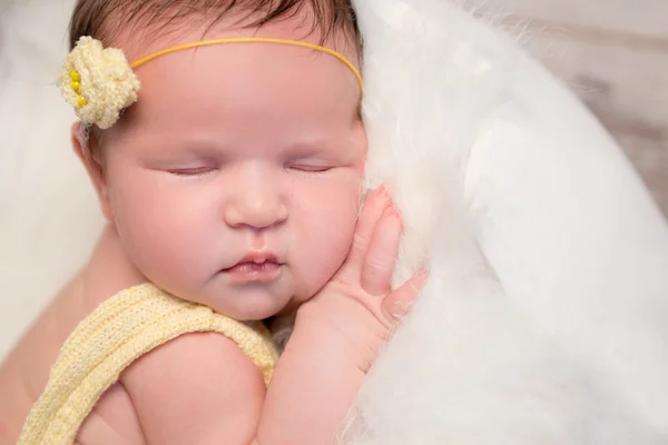 Schönes Baby im gelben Strampler, das mit überkreuzten Beinen schläft — Stockfoto