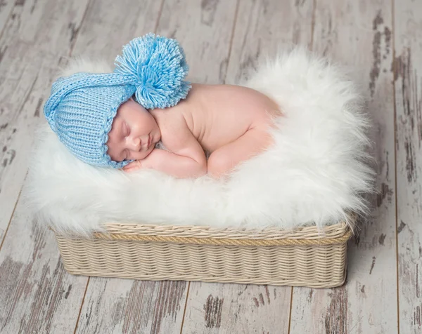Bebé en sombrero azul durmiendo en una manta mullida —  Fotos de Stock