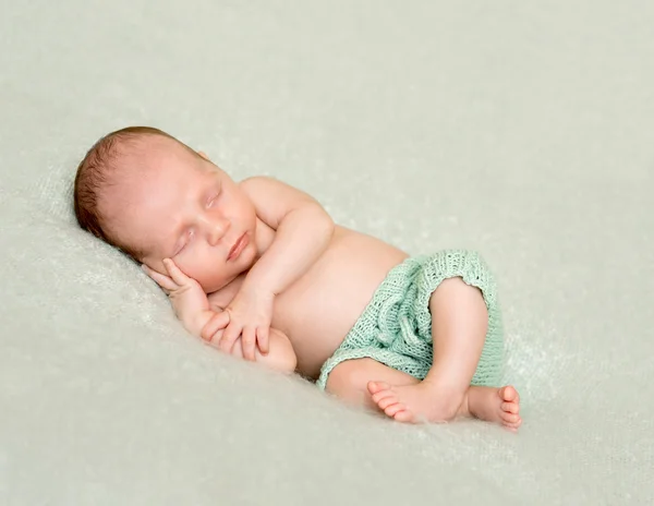 Sleeping baby with hand under his head and crossed legs — Stock Photo, Image