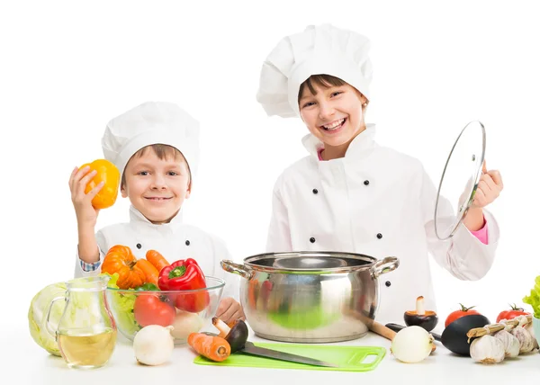 Маленькі кухарі за столом з овочами — стокове фото