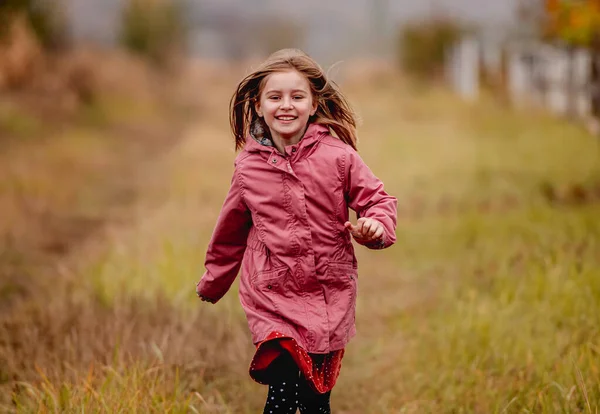 소나무 숲 속을 뛰어다니는 미소짓는 어린 소녀 — 스톡 사진