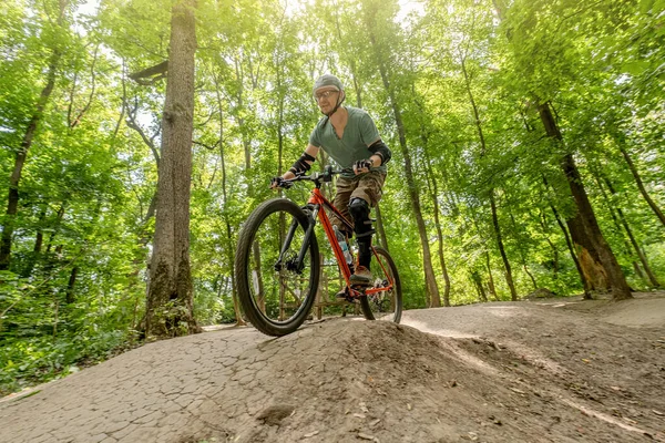 Hombre montar en bicicleta en carretera forestal — Foto de Stock