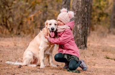 Golden Retriever ile ormanda küçük bir kız