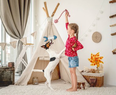 Küçük kız tilki teriyeriyle oynuyor.