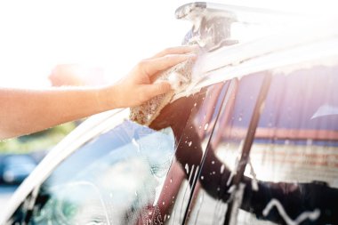 Süngerli el arabayı temizliyor.