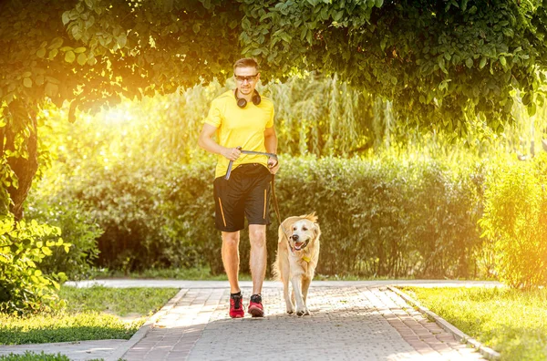 Man joggar i parken med hund — Stockfoto
