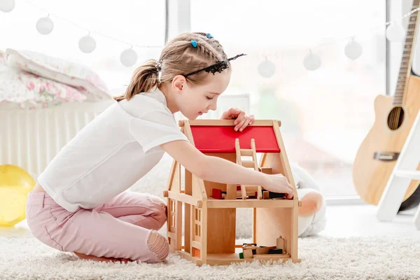 Menina bonita brincando com casa de bonecas — Fotografia de Stock
