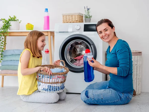 Boldog anya és kislánya ruhákat mos. — Stock Fotó