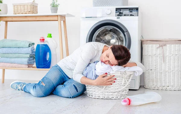 Mujer cansada descansando en la cesta de la ropa — Foto de Stock