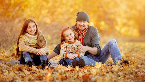Hijas y padre en hojas de otoño —  Fotos de Stock