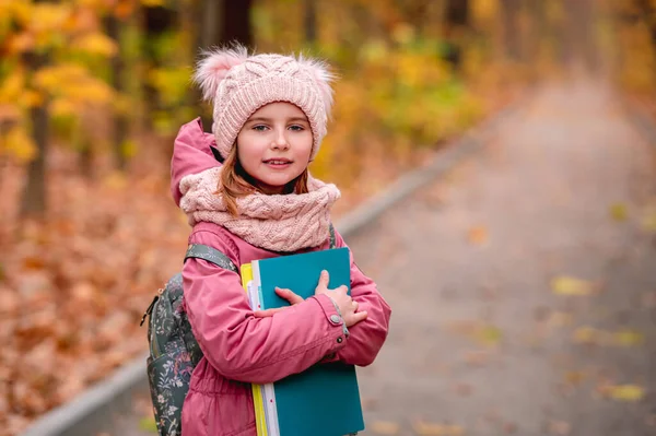Μικρό κορίτσι με σακίδιο κρατώντας φακέλους — Φωτογραφία Αρχείου