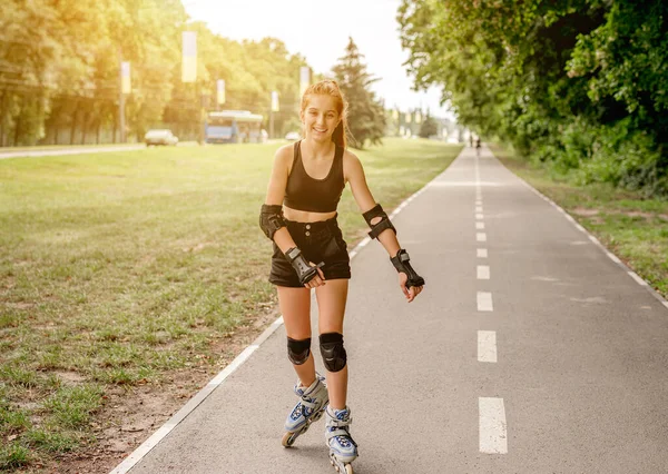 Tienermeisje in sportkleding rolschaatsen — Stockfoto