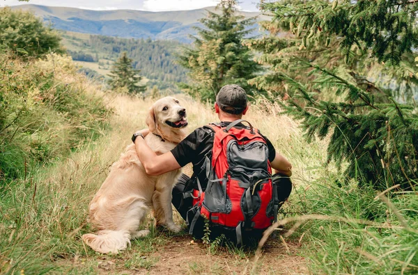 Man on trekking trail next to dog — Stock Photo, Image