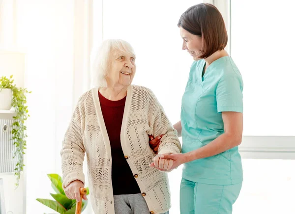 Cuidador ajudando a mulher idosa a andar — Fotografia de Stock