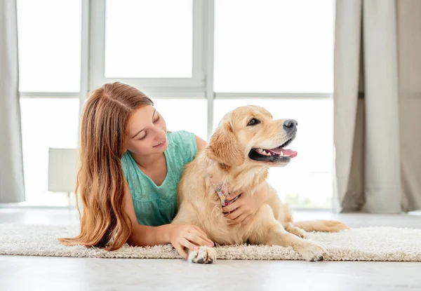 Fiatal lány fekszik golden retriever — Stock Fotó