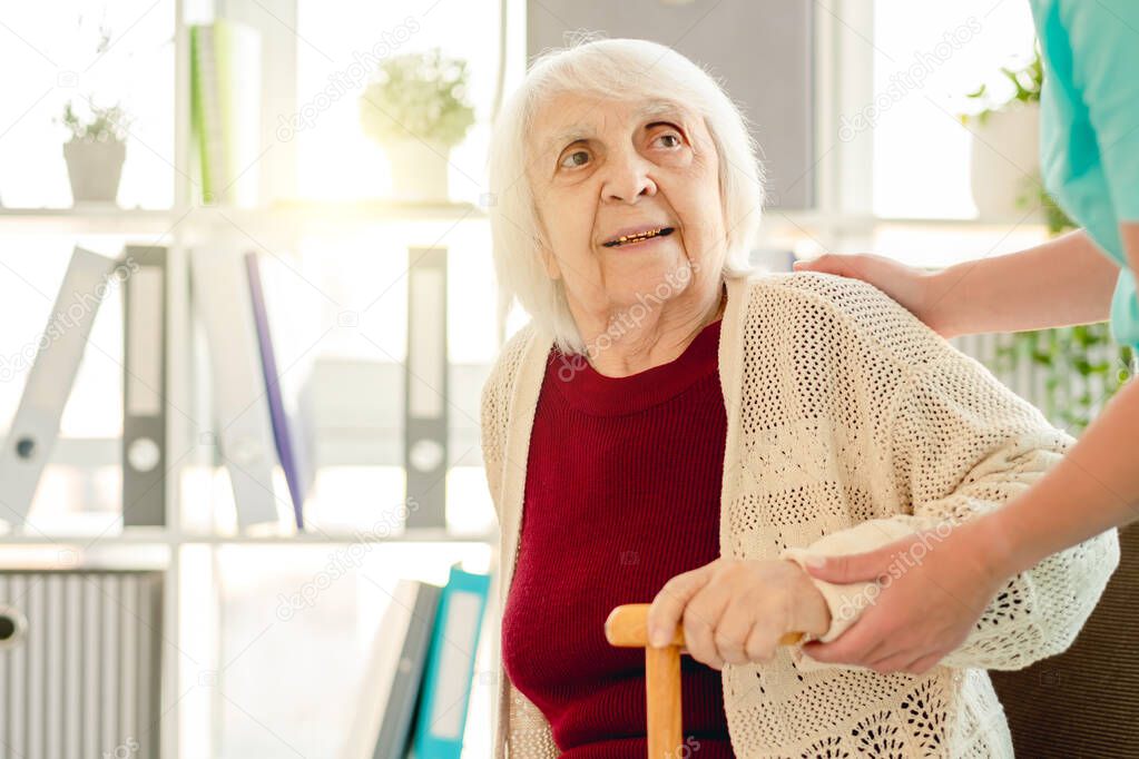 Old woman in hands of caregiver