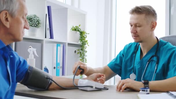 Terapeuta medindo a pressão arterial do paciente — Vídeo de Stock