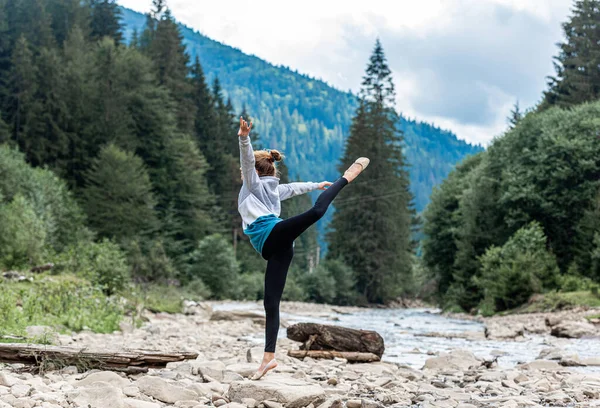 Young girl performing gymnastics in nature — Stock Photo, Image