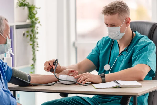 Therapeut meten van bloeddruk van de patiënt — Stockfoto