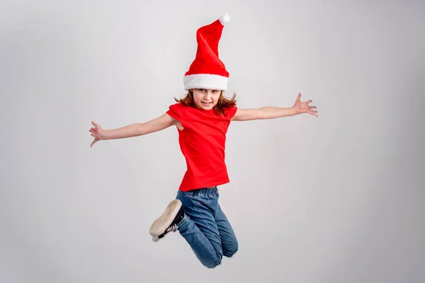 Little girl in santa hat jumping high — Stock Photo, Image