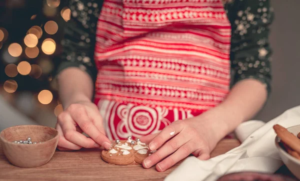Menina em avental festivo decorar pão de gengibre — Fotografia de Stock