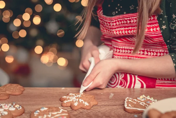 Fille décoration pain d'épice flocon de neige à la maison — Photo